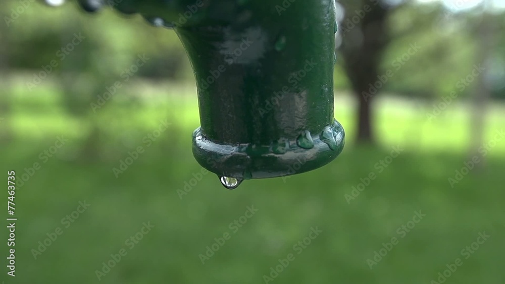 Detail shot of drop of water falling from the water pump Detail shot of drop of water falling from the water pump