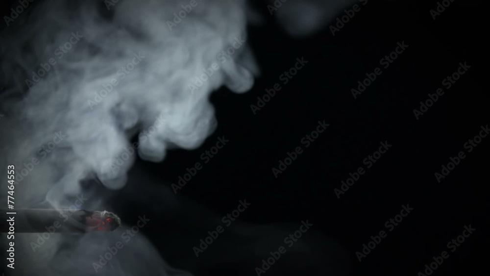 Cigarette with exhaled smoke brooding in the air
