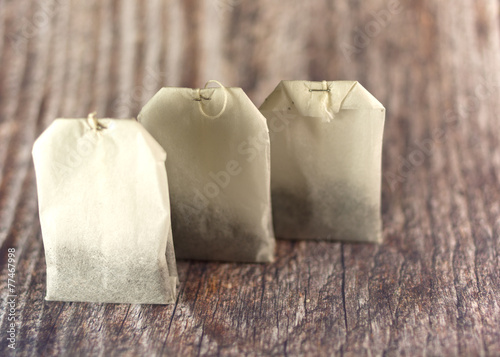 Obraz na płótnie Three tea bags in raw on wooden background w salonie