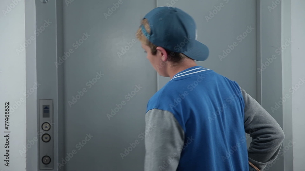 Boy waits for an elevator shot from behind Boy waits for an elevator shot from behind