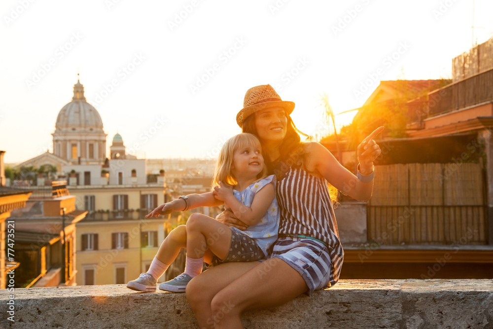 Fototapeta premium Mother and baby girl sitting on street in Rome