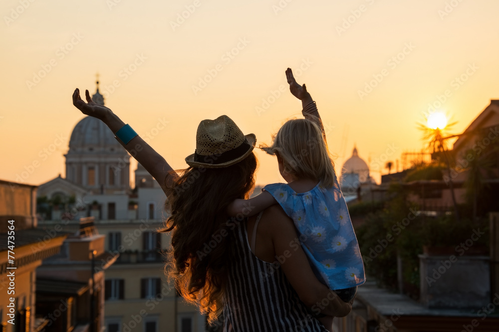 Fototapeta premium Silhouette of mother and baby girl looking on rooftops of Rome