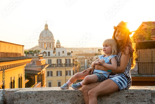 Mother and baby girl sitting on street  in Rome