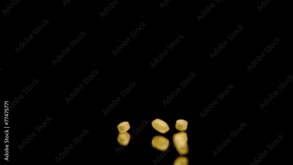 Orange tablets falling and bouncing on the reflective surface Orange tablets falling and bouncing on the reflective surface