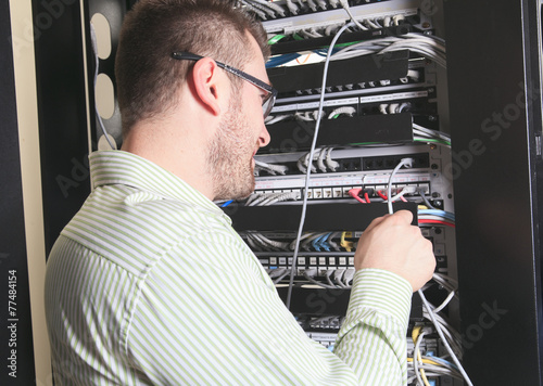 A happy worker technician at work with computer. photo