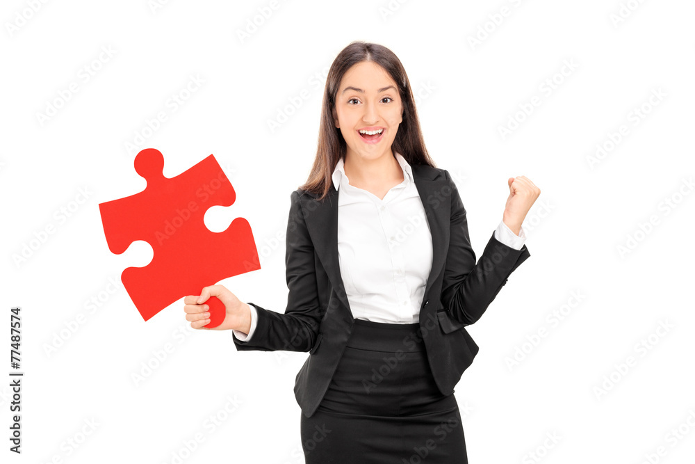 Delighted businesswoman holding a piece of puzzle Delighted businesswoman holding a piece of puzzle
