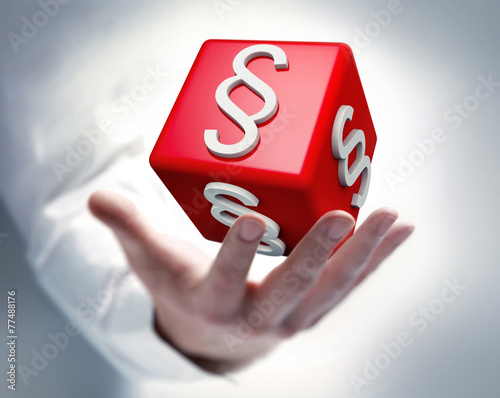 Hand mit Paragraphenwürfel