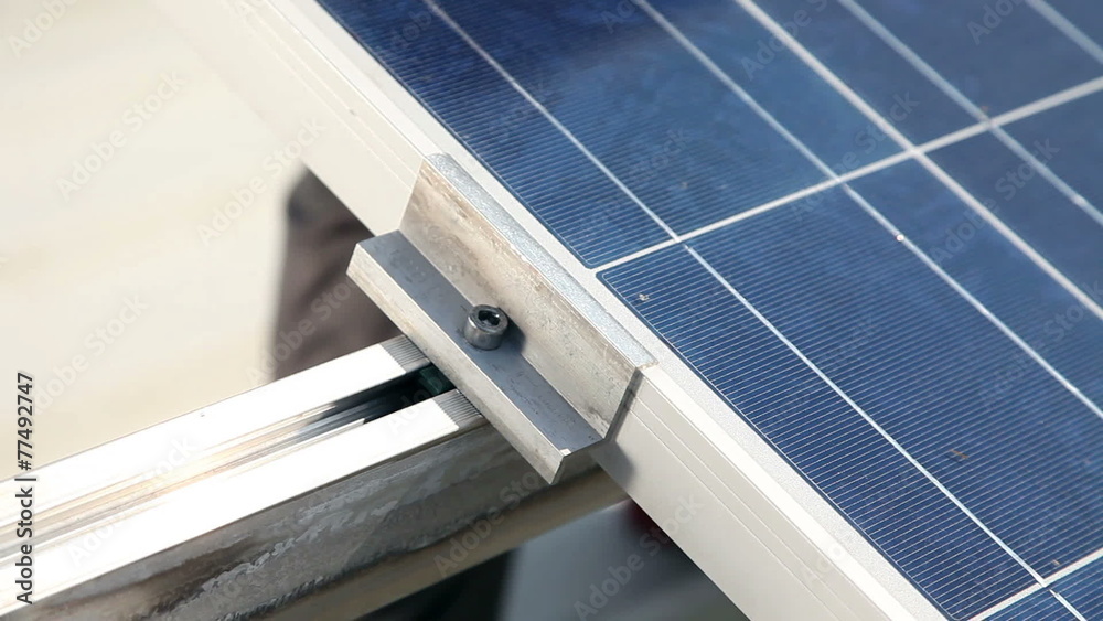 Worker screwing on a solar modul