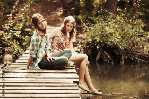Two young fashion teen girls in a summer forest