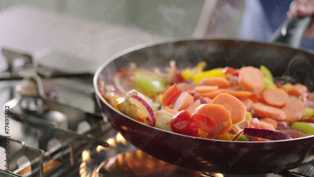Frying vegetables and chicken white meat.