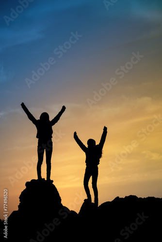 Two young girls on top during sundown.