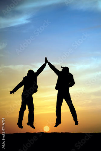Two man holding for hands and jumping