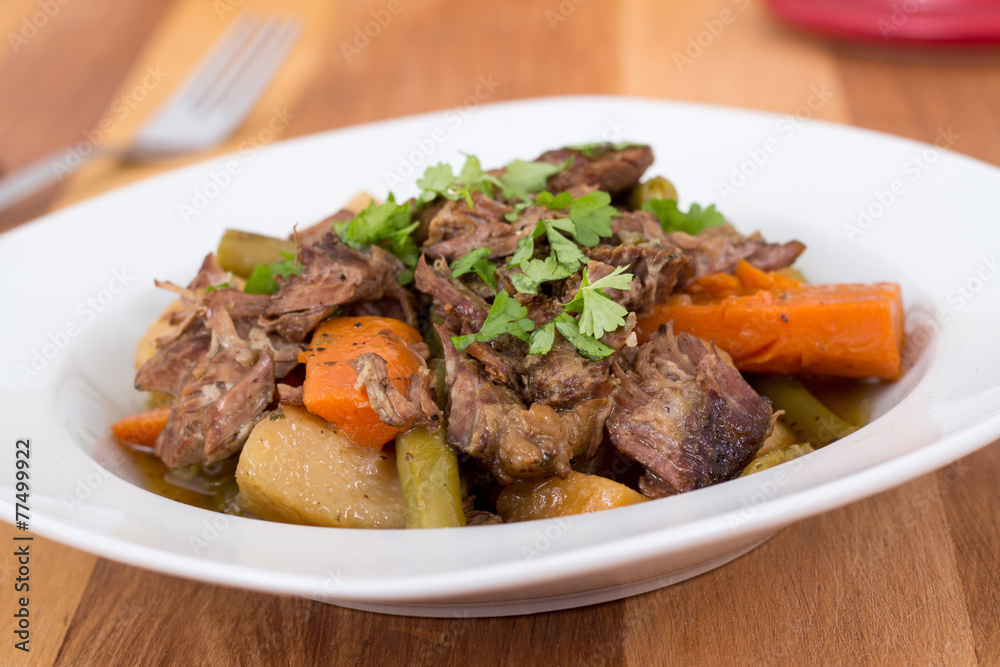 braised beef pot roast stew with vegetables on table