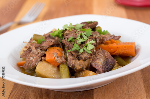 braised beef pot roast stew with vegetables on table