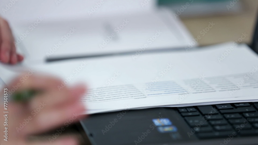 a secreterian who is very busy according to her table ful of documents and searching for documents in her office a secreterian who is very busy according to her table ful of documents and searching for documents in her office