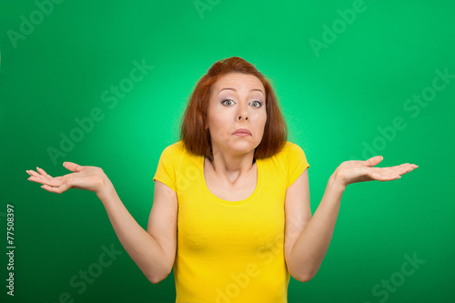 puzzled clueless woman shrugs shoulders green background 