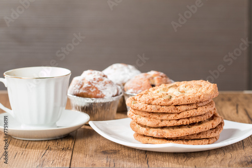 Cup of coffee with tasty  cookies and muffins