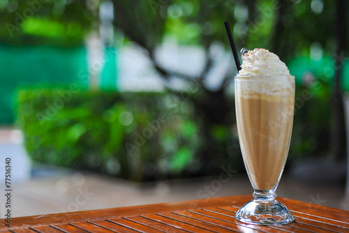 A glass of ice coffee in garden background