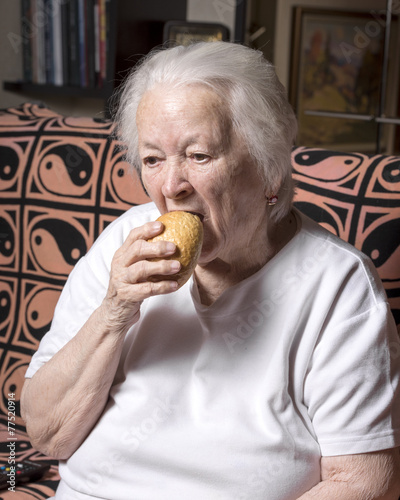 Old woman eating bread