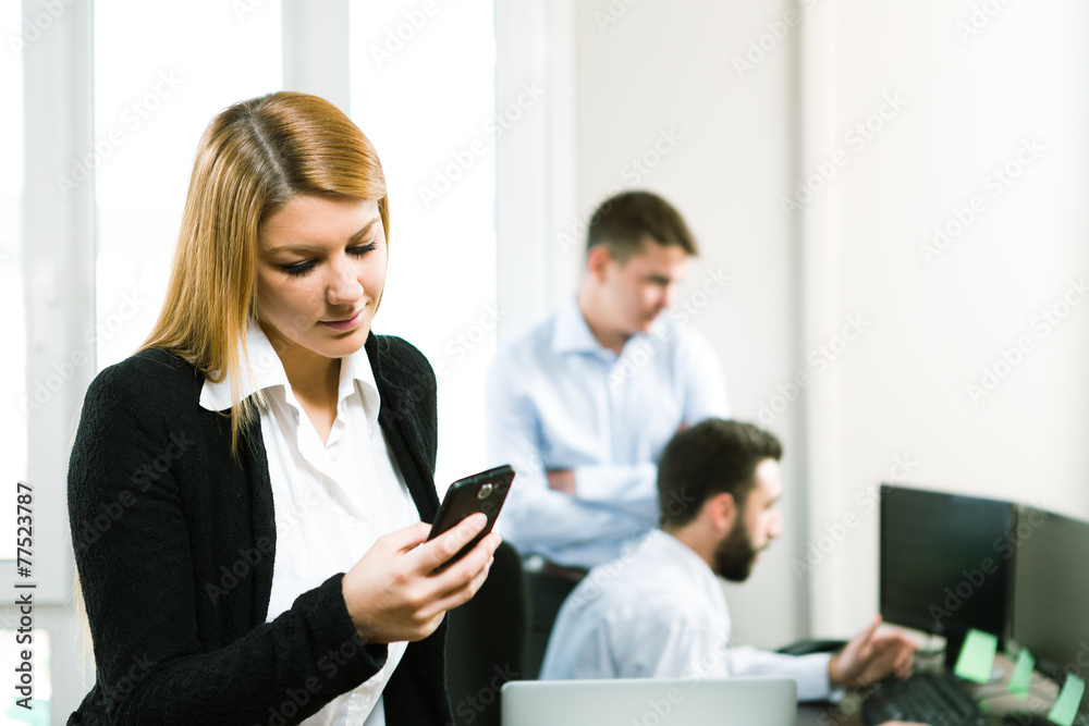 business people working in an office, young woman using a mobile business people working in an office, young woman using a mobile