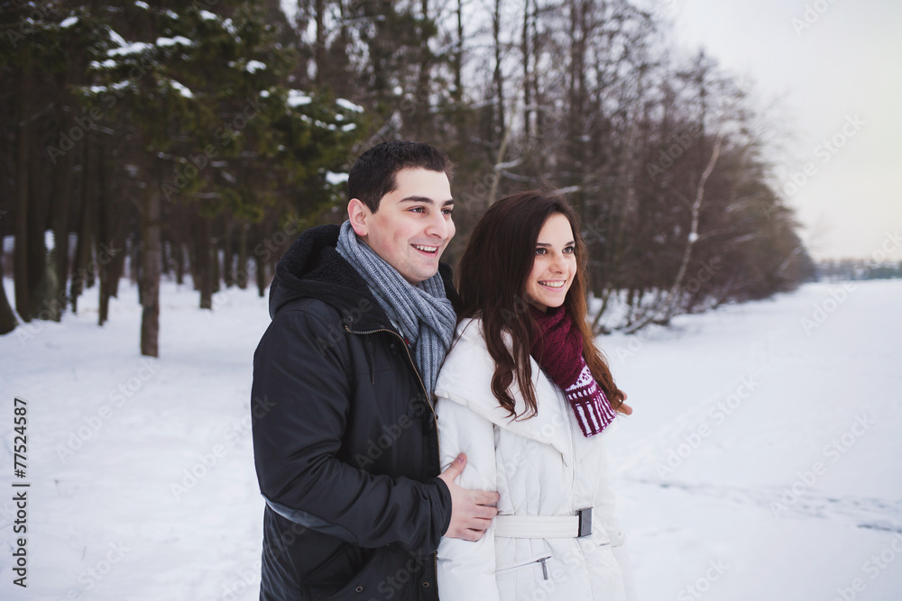 young couple smiling in winter forest