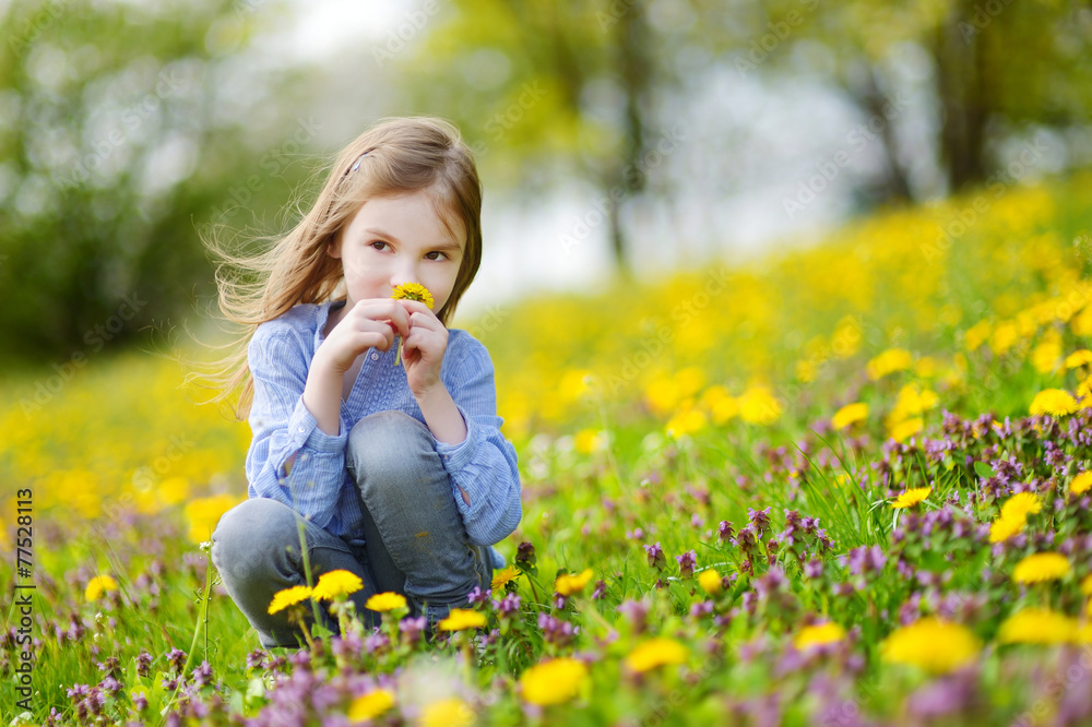 Adorable girl in blooming dandelion flowers Adorable girl in blooming dandelion flowers