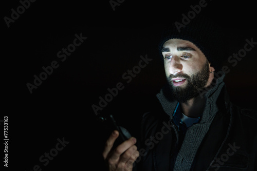 Young man uses his mobile at night