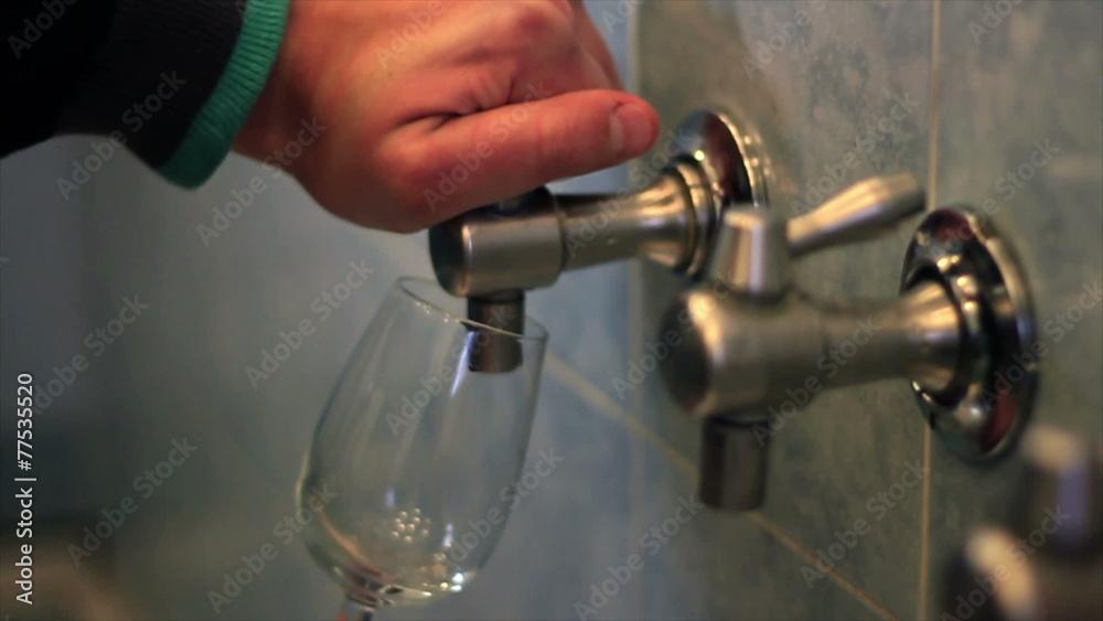 Close up shot of a man`s hand pouring white wine in the glass Close up shot of a man`s hand pouring white wine in the glass