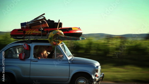 Family driving in a small car toward summer holiday on beach