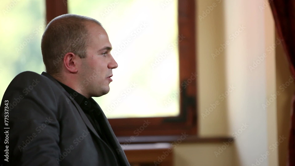 Close up of a business man sitting on an old fashioned sofa
