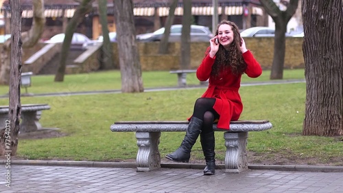 Girl in a red coat on a park bench - waiting photo