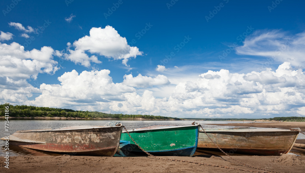 Three fishing boats on the beach at the river