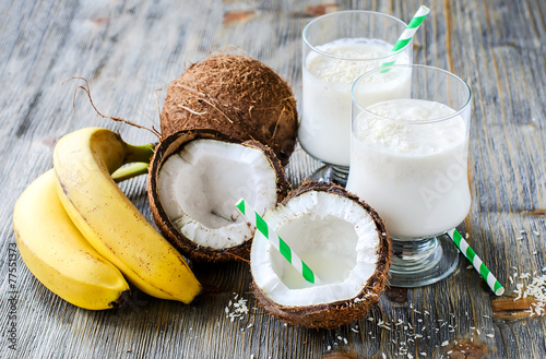 Coconut milk smoothie drink with bananas on wooden background