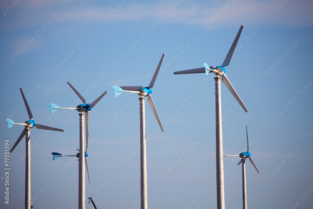 Green renewable energy concept - wind generator turbines on blue