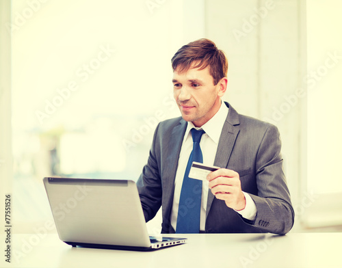 man with laptop and credit card in office