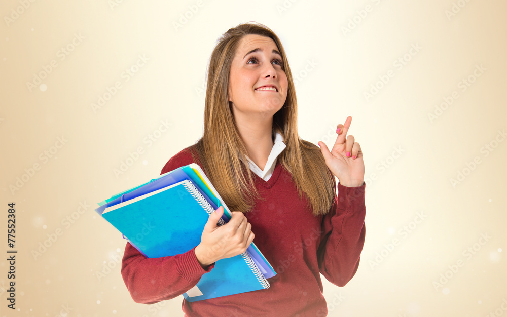 Student with her fingers crossing over white background Student with her fingers crossing over white background