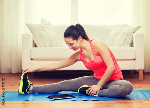 smiling teenage girl streching on floor at home