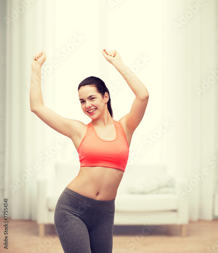 smiling teenage girl in sportswear dancing