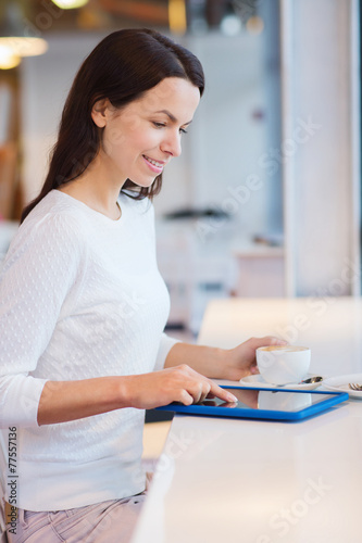 smiling woman with tablet pc and coffee at cafe
