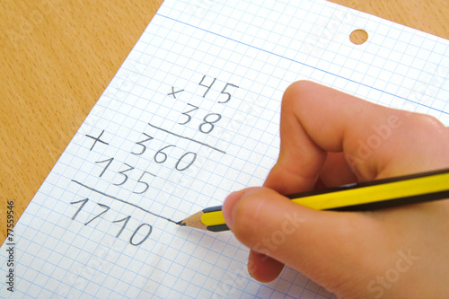Child doing a math multiplication at school.