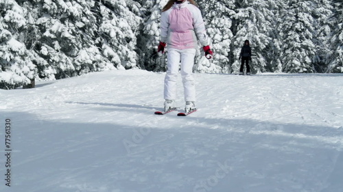 a young teenaged girl while skiing and enjoying in the idyllic winter time soroundings photo