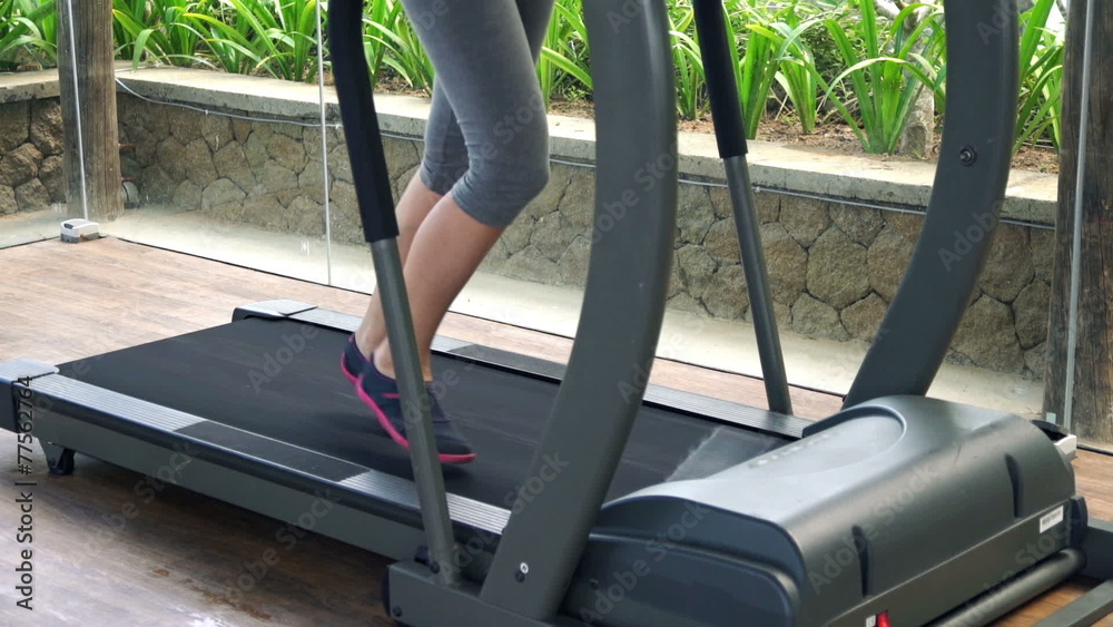 Woman legs running on treadmill in gym 