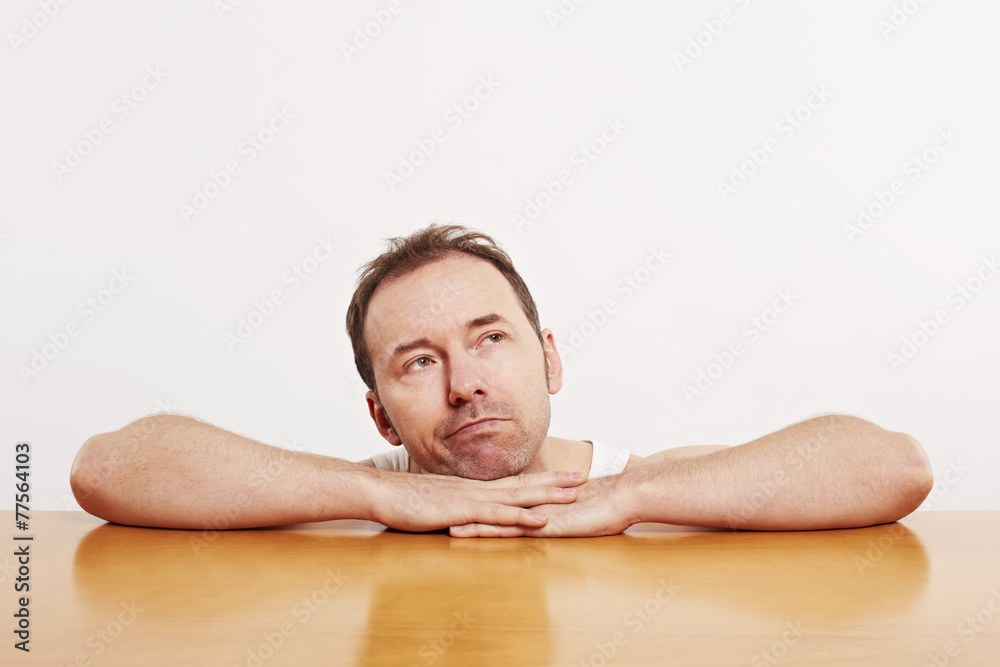 Mann stützt sich das Kinn am Tisch auf den Händen Mann stützt sich das Kinn am Tisch auf den Händen