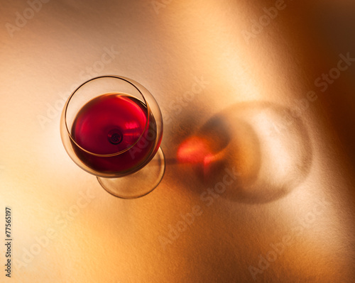 Calice di vino rosso su fondo caldo con ombra.Vista dall'alto photo