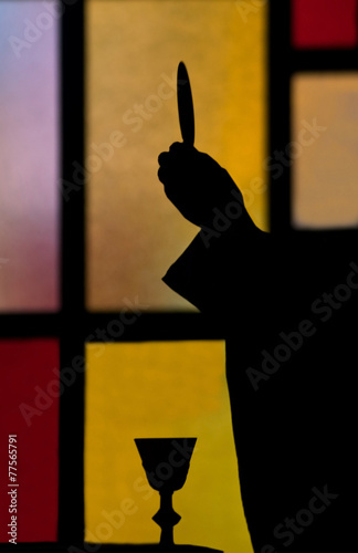 priest lifting host silhouette
