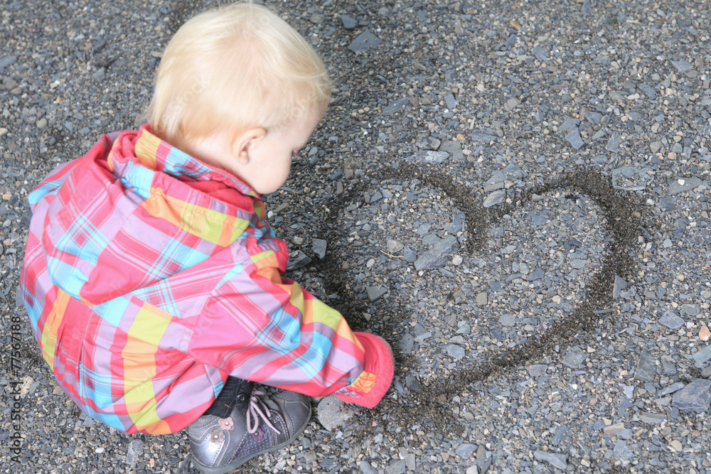 Naklejka premium young girl holding gravel in shape of heart (shallow depth of