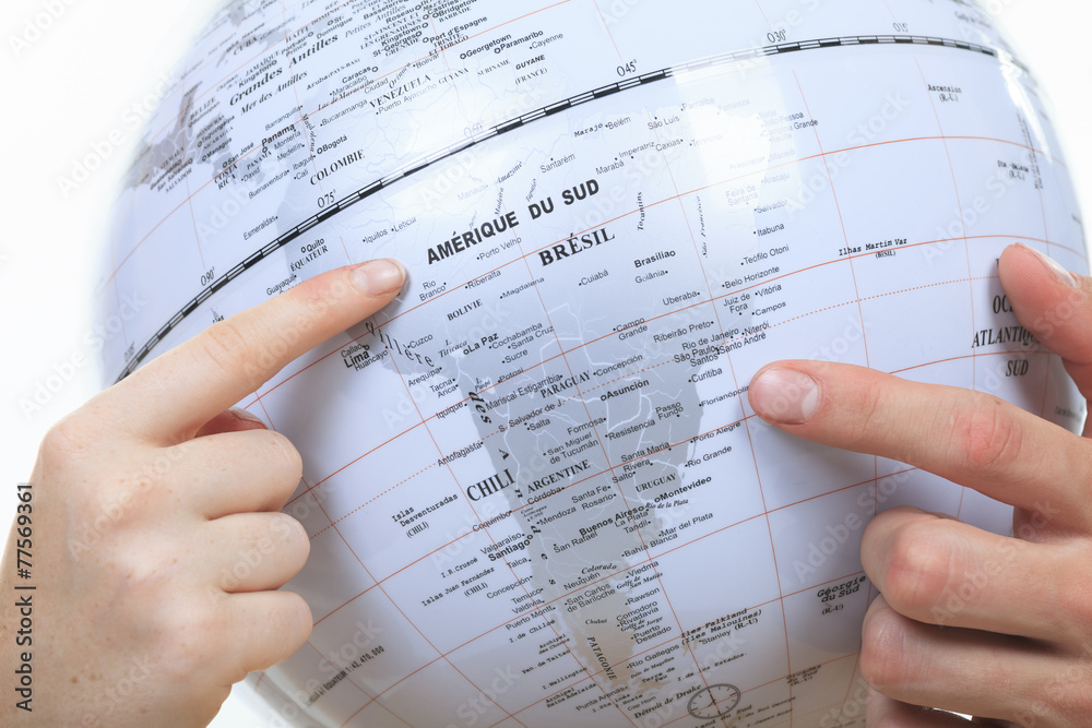 Fototapeta premium Excited young couple planning their holiday holding up a globe
