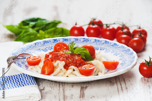 Healthy plate of Italian spaghetti topped with a tasty tomato an