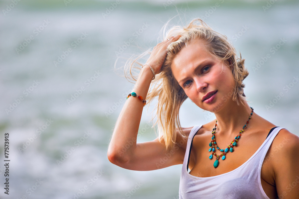 Beautiful young blonde woman posing outdoor at the rocky sea sho Beautiful young blonde woman posing outdoor at the rocky sea sho