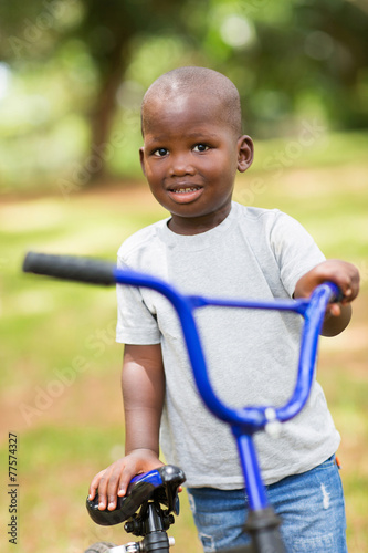 african little boy with his bike outdoors